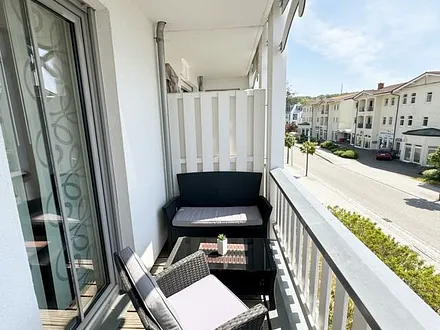 bestuhlter Balkon mit einem Tisch, 2 Stühlen sowie einer gemütlichen Sitzgruppe