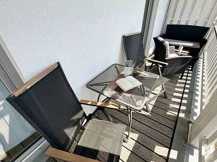 bestuhlter Balkon mit einem Tisch, 2 Stühlen sowie einer gemütlichen Sitzgruppe