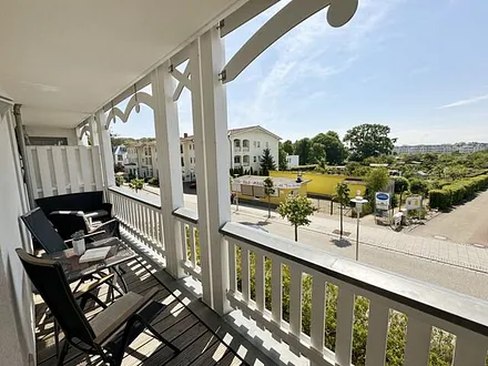 bestuhlter Balkon mit einem Tisch, 2 Stühlen sowie einer gemütlichen Sitzgruppe