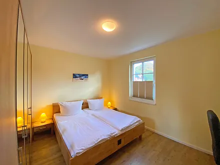 1. Schlafzimmer mit Doppelbett (2x 0,90 m x 2,00 m), 2 Nachtischkonsolen mit Beleuchtung, Sideboard mit Flachbild-TV und Kleiderschrank