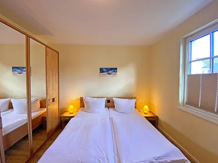 1. Schlafzimmer mit Doppelbett (2x 0,90 m x 2,00 m), 2 Nachtischkonsolen mit Beleuchtung, Sideboard mit Flachbild-TV und Kleiderschrank