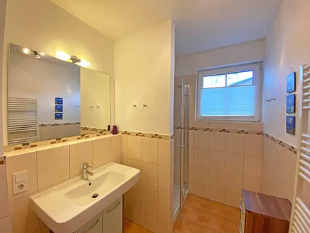 Tageslichtbad verfügt über Waschtisch, Handtuchtrockner, WC und eine Dusche mit flachem Einstieg