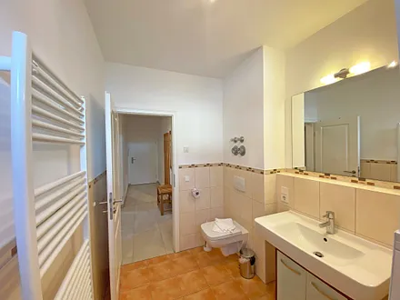 Tageslichtbad verfügt über Waschtisch, Handtuchtrockner, WC und eine Dusche mit flachem Einstieg