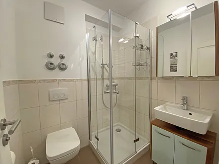 innenliegendes Badezimmer verfügt über Waschtisch, WC, Fön, Handtuchtrockner sowie eine Dusche mit flachem Einstieg