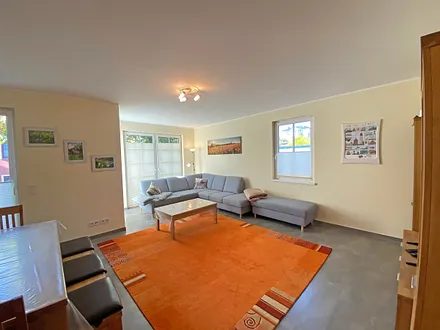 Wohnzimmer mit gemütlicher Eck- Couch mit Hocker, Couchtisch, Stehlampe, zwei Vitrinen, TV-Board mit Flachbild-TV sowie DVD-Player und CD-Player