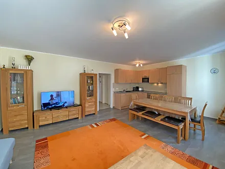 Wohnzimmer mit gemütlicher Eck- Couch mit Hocker, Couchtisch, Stehlampe, zwei Vitrinen, TV-Board mit Flachbild-TV sowie DVD-Player und CD-Player