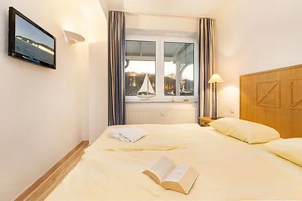 Ein großer Kleiderschrank befindet sich im Wohnzimmer. Durch das Fenster sehen Sie den rückwärtigen, überdachten Laubengang/Gemeinschaftsbalkon.