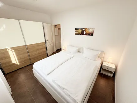 Schlafzimmer mit Doppelbett und Kleiderschrank