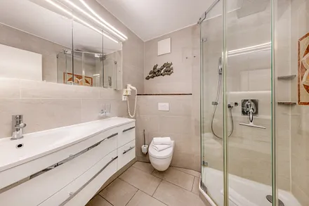 Das Bad bietet Ihnen Echtglasdusche, einen großen Waschtisch und WC.