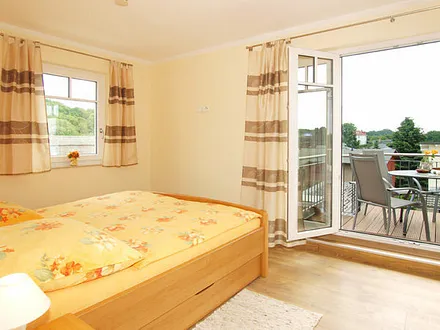 Schlafzimmer mit Doppelbett und Zugang zum Balkon