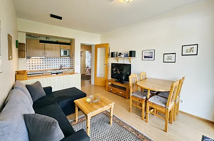 Wohnzimmer mit Flat-TV, Essplatz und Küchenzeile