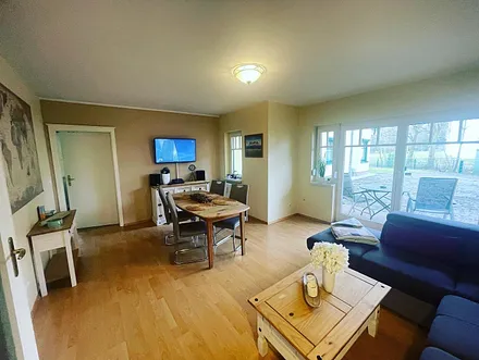 Das helle Wohnzimmer mit Blickrichtung Küche bietet Ihnen einen gemütlichen Aufenthalt.