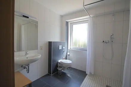 Bad mit ebenerdiger Dusche und Fenster
