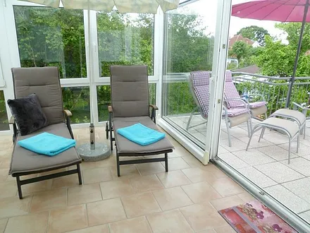 Großer Wintergarten mit Relaxliegen und Auflagen, Sonnenschirm