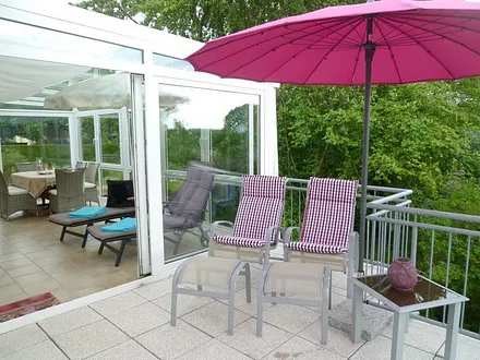 Riesiger Wintergarten mit Relaxliegen und traumhafter Terrasse mit bequemen Stühlen, nach Süden und Westen orientiert