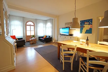 Wohnzimmer mit Esstisch, Sitzecke und TV