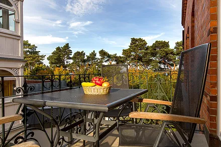 Die Ferienwohnung DolceVita hat einen schönen Balkon mit typischem schmiedeeisernen Geländer und wunderbarem Blick auf die Seebrücke und die Ostsee. Der Meerblick variiert mit Schnitt der Dünenbäume. 