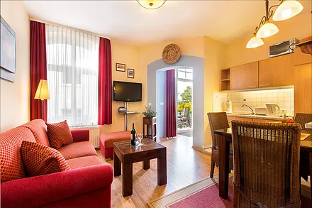 Die Wohnung ist in geschmackvollen Wohlfühlfarben eingerichtet. Von der Couch aus sehen Sie durch das Balkonfenster aufs Meer.