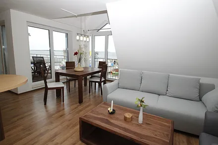 Wohnzimmer mit Balkon und Panoramablick auf die Hafenpromenade