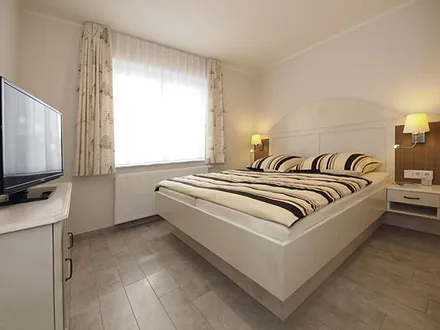 Schlafzimmer mit Doppelbett und 2. Flachbildfernseher