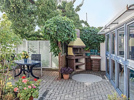 Grillplatz mit Sitzecke und Blick auf den Wintergarten.