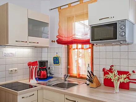 Küche mit Herd, Kaffeemaschine und Mikrowelle.