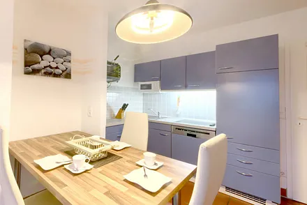 Der große Esstisch und die Küche mit Geschirrspüler