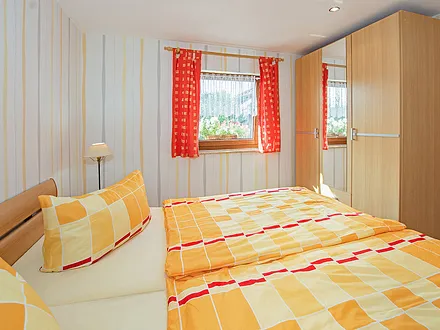 Schlafbereich mit Doppelbett und Schrank.