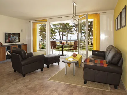 großzügiger Wohnbereich mit Zugang zum Balkon (Seeblick)
