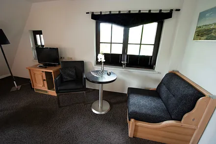 Sitzgruppe, Minibar sowie zusätzliche Aufbettungsmöglichkeit (Schlafsessel)