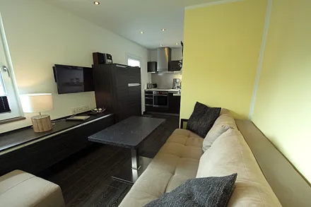 Blick vom Schlafzimmer in den Wohnbereich, mit integrierter Einbauküche