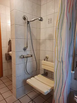 Heruntergeklappter Duschsitz