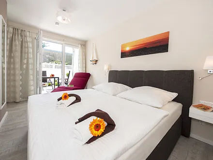 Schlafzimmer mit Doppelbett und Relaxsessel