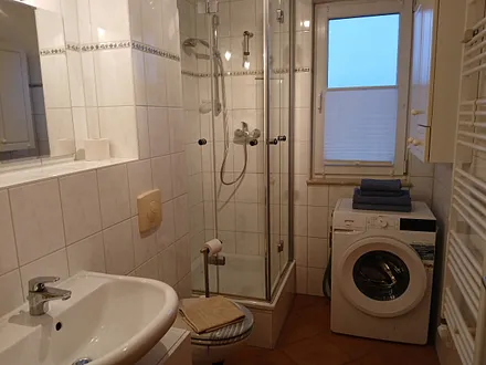 Bad mit Dusche, Waschbecken, WC und Waschmaschine