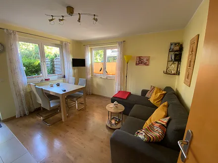 Wohnzimmer mit Schlafcouch und Essecke