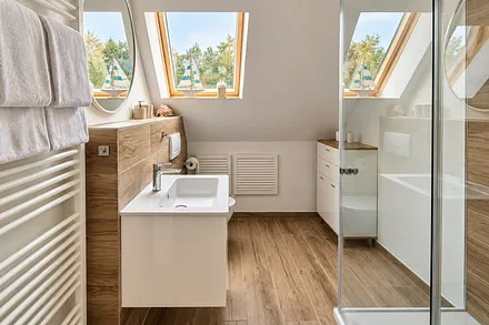 Badezimmer mit Dusche und natürlichem Tageslicht.