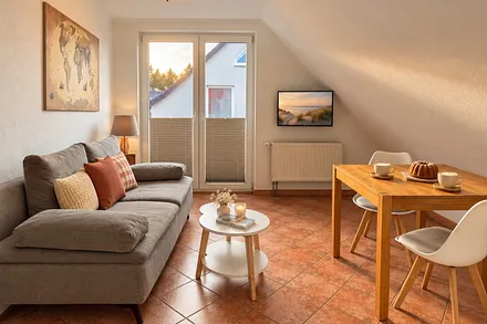 Wohnzimmer mit Balkon und Flachbild-TV.