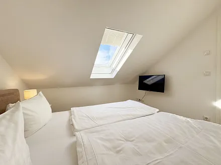 1. Schlafzimmer mit Doppelbett und TV