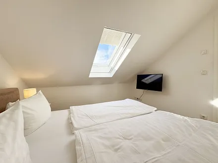 1. Schlafzimmer mit Doppelbett und TV