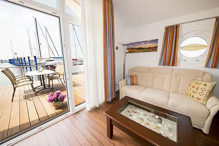 Gemütliche Sitzecke mit Schlafcouch und Blick auf die Terrasse