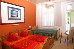 Schlafzimmer 1 mit einem Doppelbett  und einem Einzelbett ,Kleiderschrank, TV und Ausgang zum Balkon