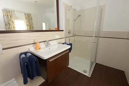 Das Badezimmer mit großzügiger Dusche und WC