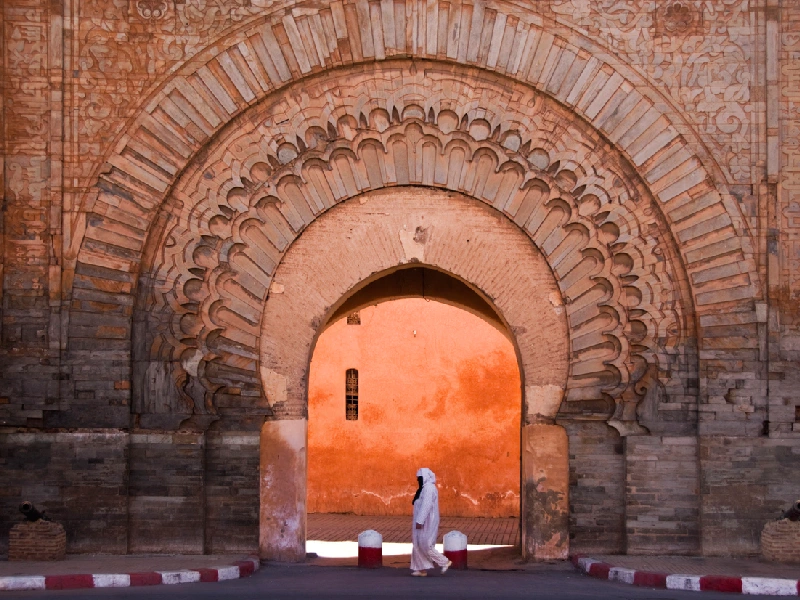 Veiled woman passes Bab Agnaou gate in Marrakech.