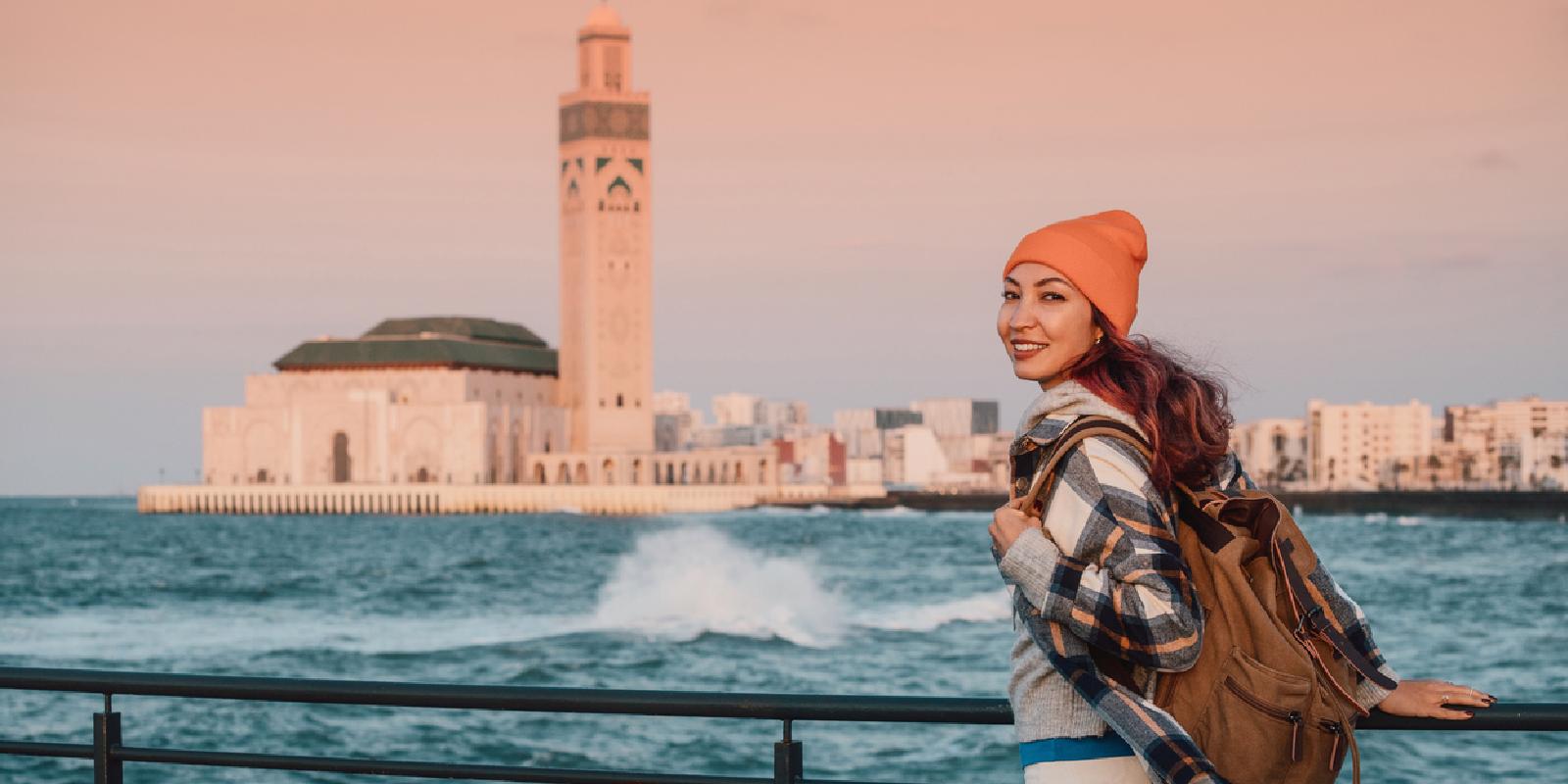 Young woman enjoys the view of Hassan II Mosque in Casablanca.
