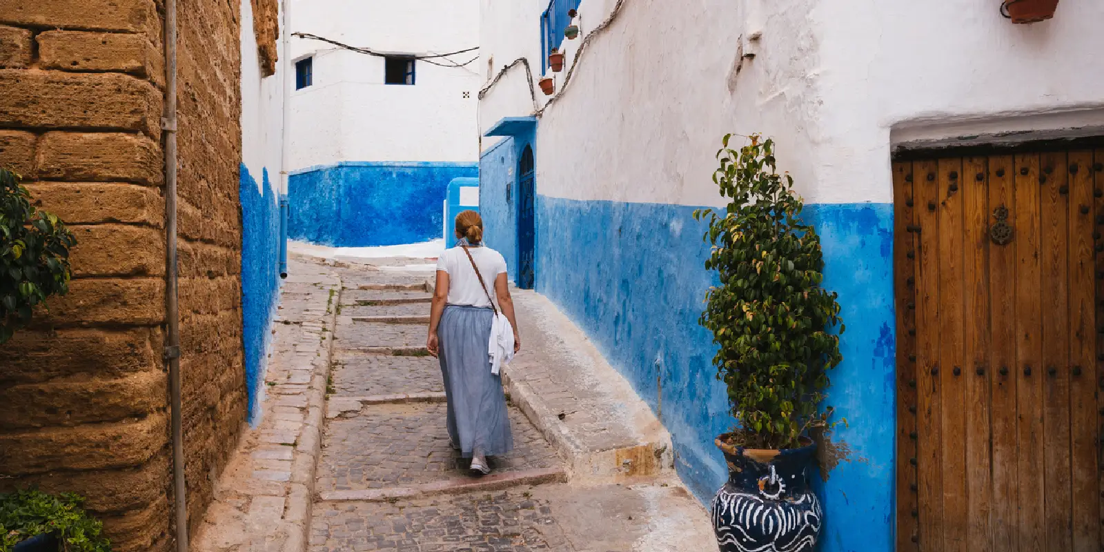 Tourist woman walking in Rabat’s Old Medina alley.