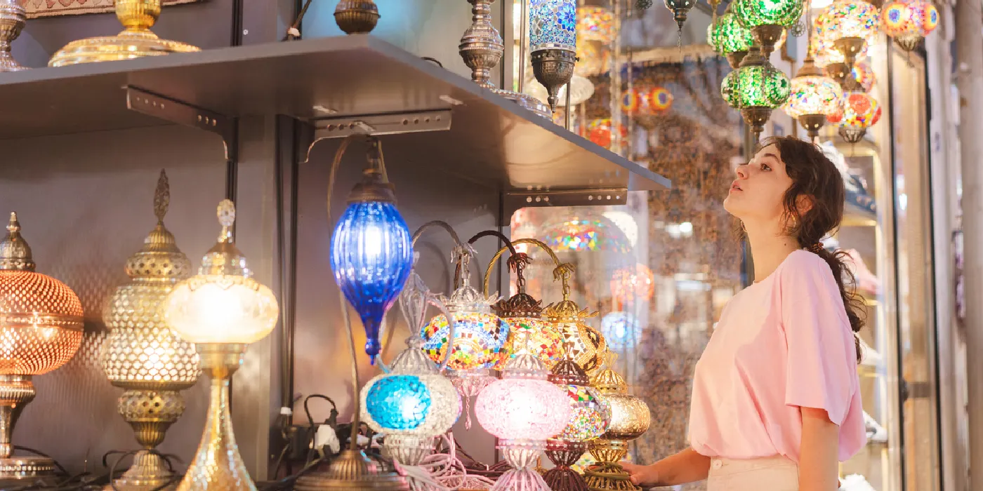 Female traveler admiring colorful lamps in Istanbul’s Grand Bazaar.