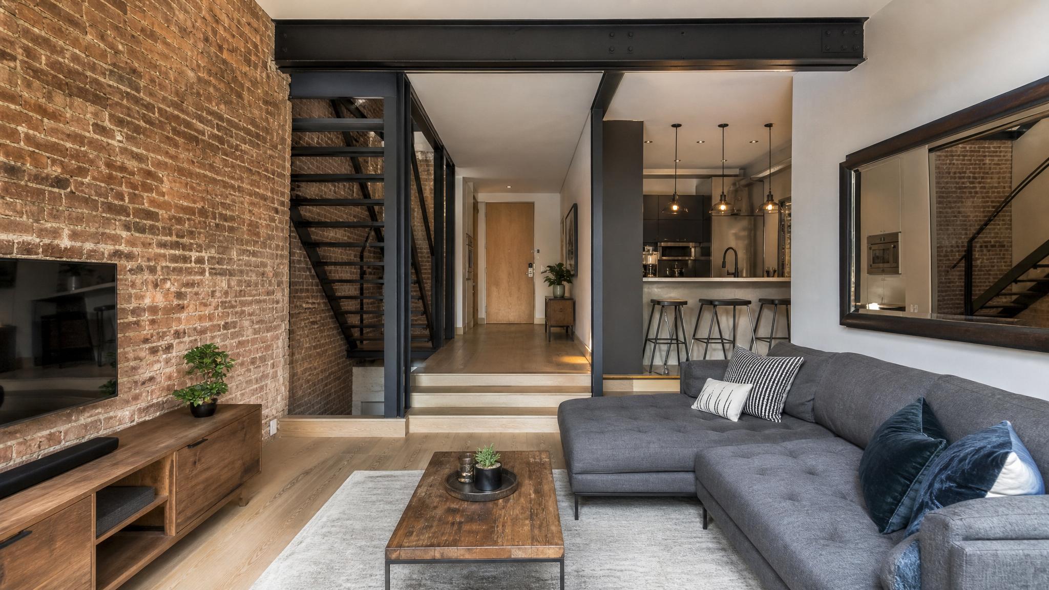 Industrial small living room showcasing raw materials like exposed brick and steel beams.
