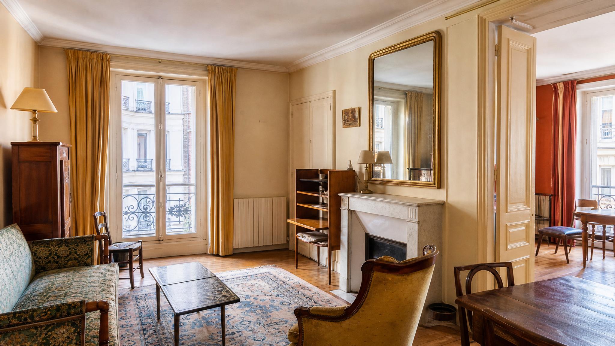 Before image of a small Parisian living room with outdated decor.