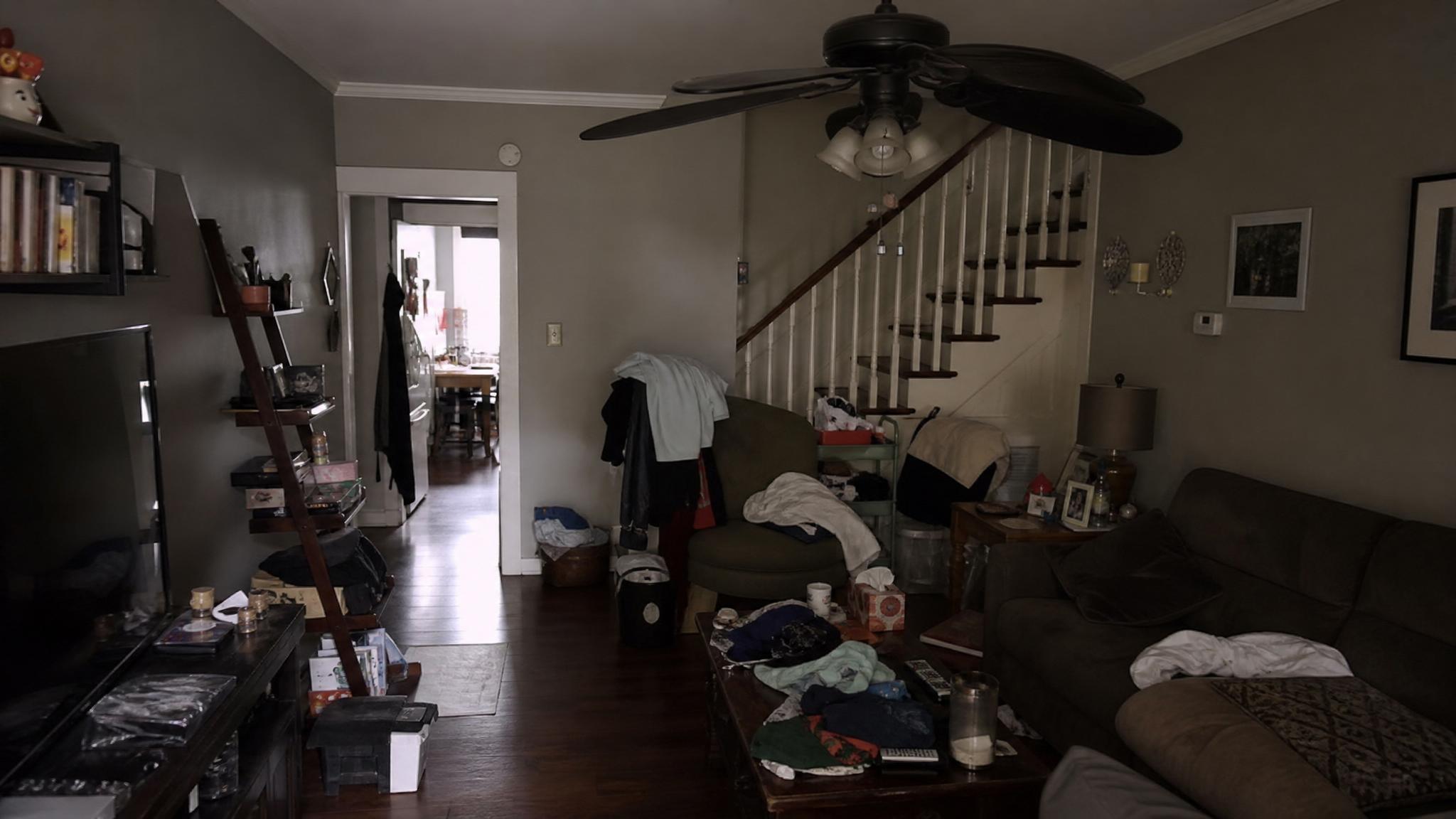 Before transformation: cluttered and dark living room in a row house.