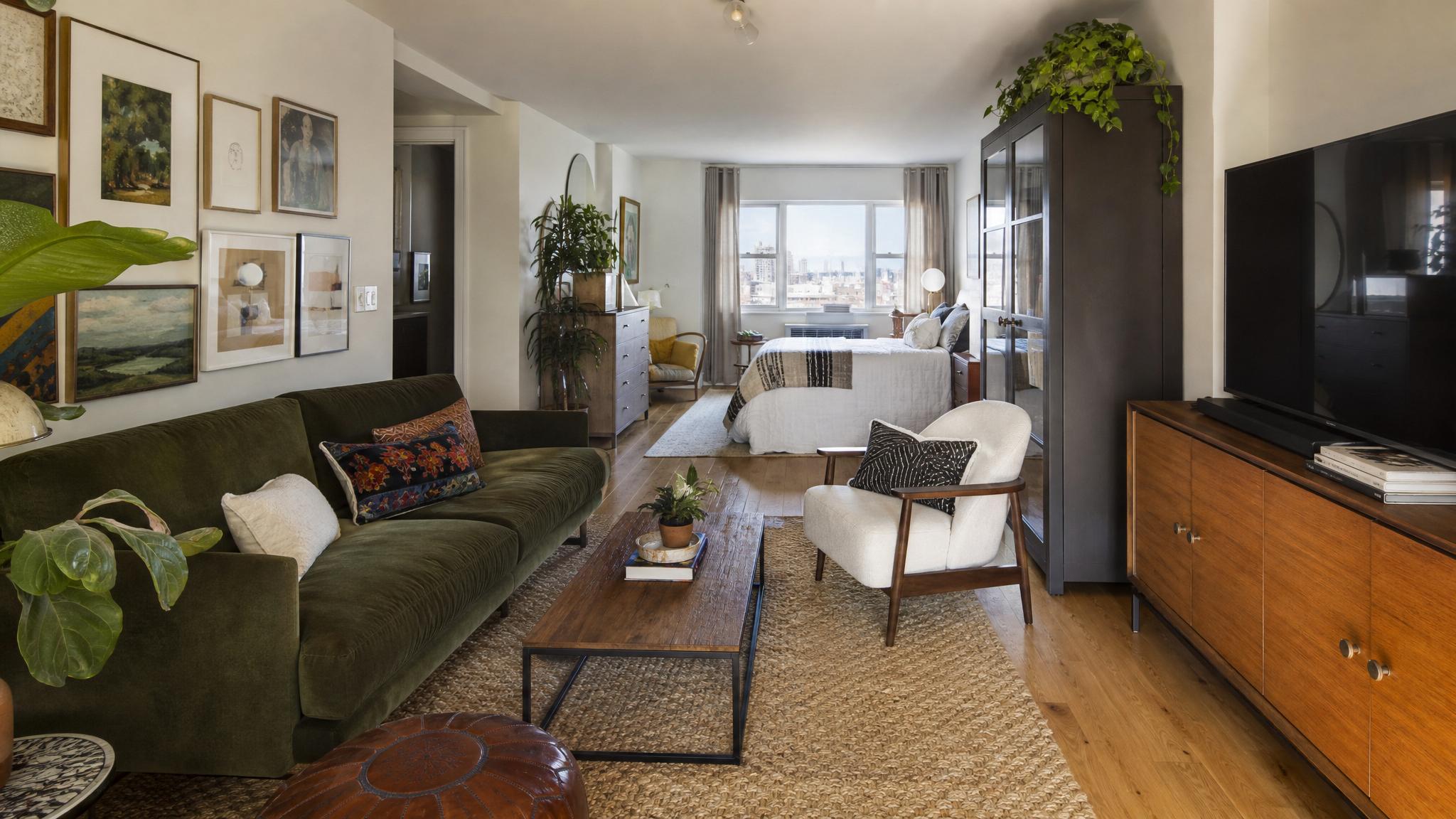 An eclectic living room setup showcasing various furniture styles in a small studio apartment.